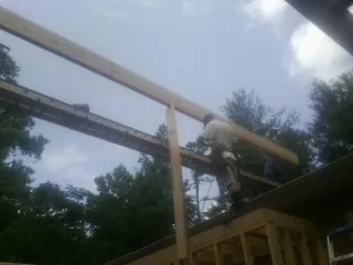 Carpenter setting a ridge beam over a new addition frame — Ice Dam Removal by Roofing Brothers in Mounds