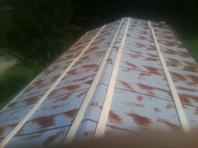 Rusted metal roof panels with new wood purlins before replacement — Storm Damage Roof Repair in Mounds by Roofing Brothers