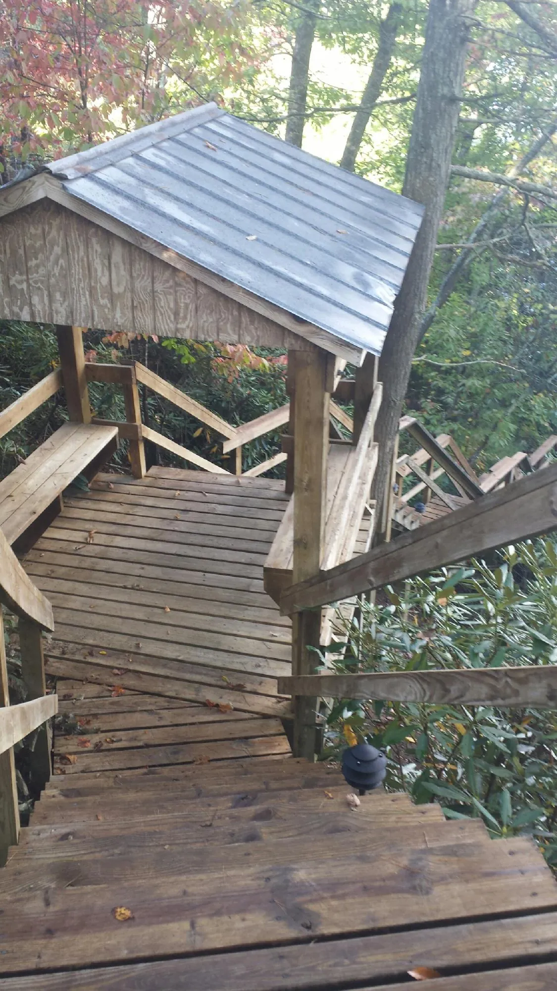 Metal roofed shelter over wooden steps on a wooded walkway — Skylight Repair & Installation work by our crew in Mounds