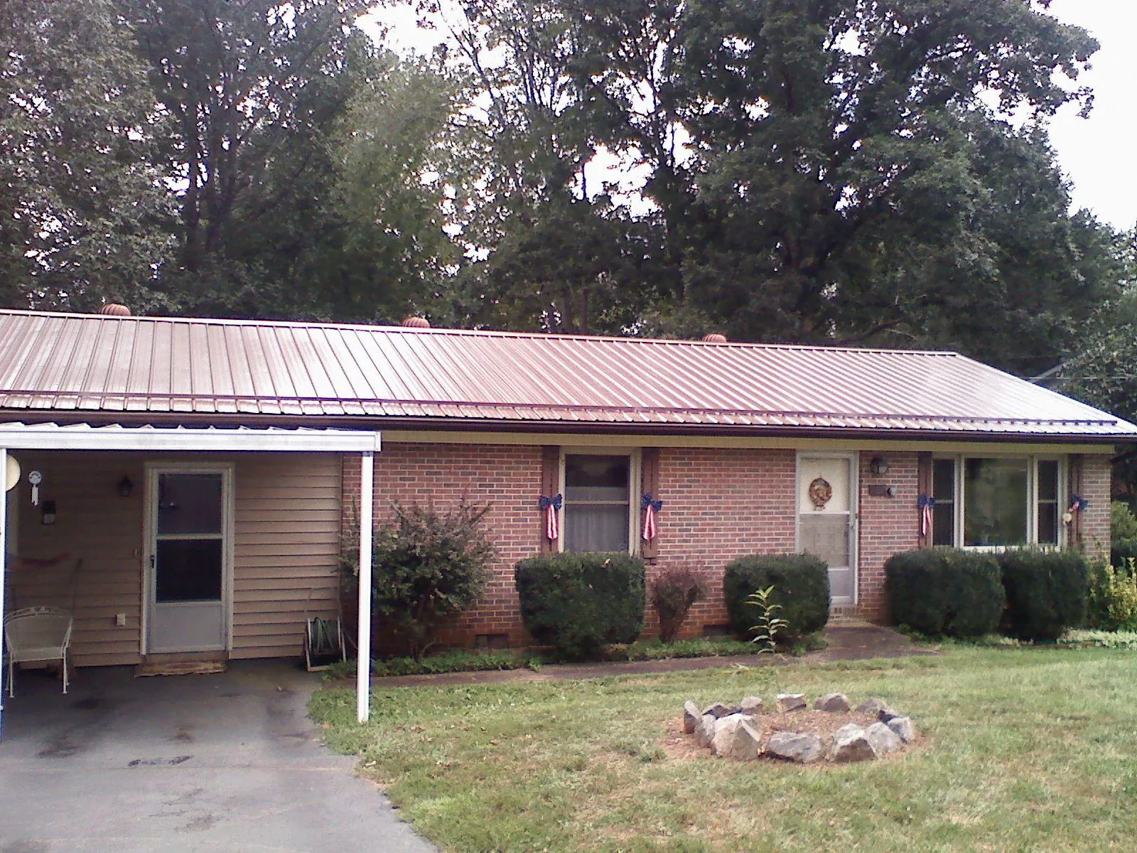 Bronze metal roof and carport on a brick ranch home — Roof Repair work by our crew in Mounds