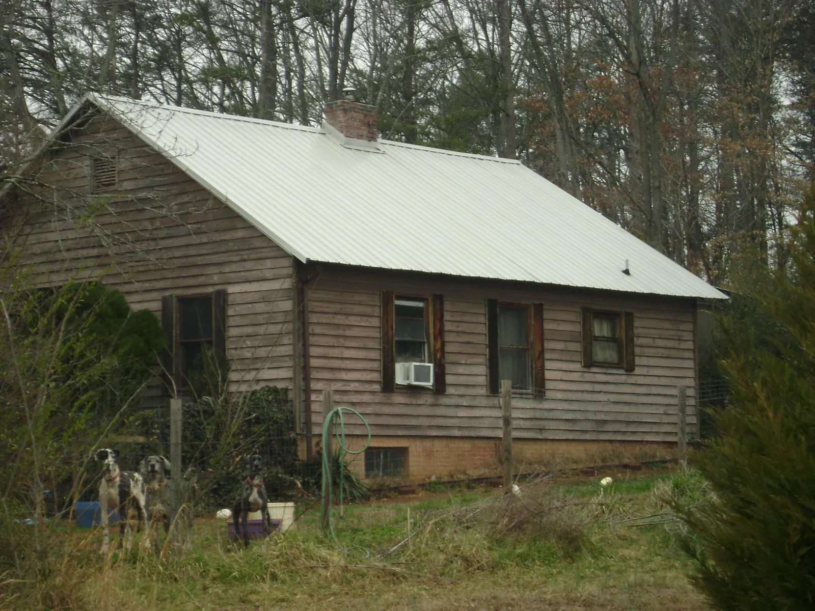 White metal roof on an old wood sided farmhouse, from a Metal Roof Installation job in Mounds